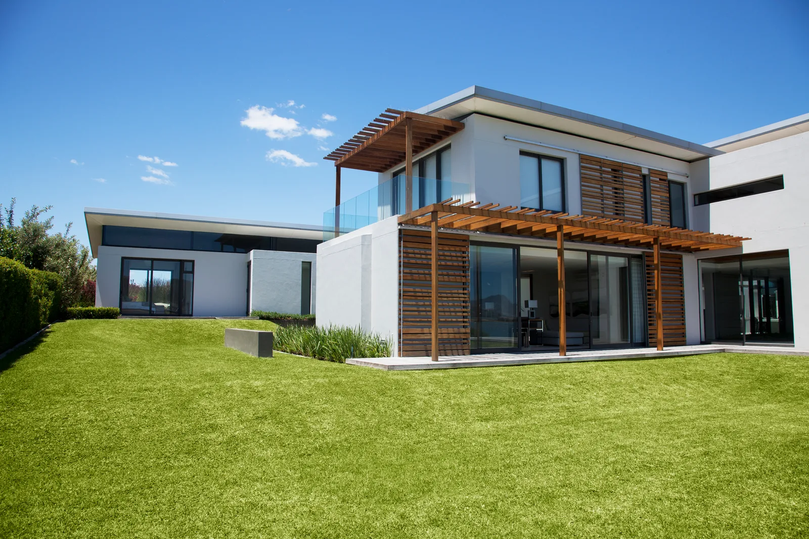 Contemporary house with timber louvered screens shading a glazed elevation