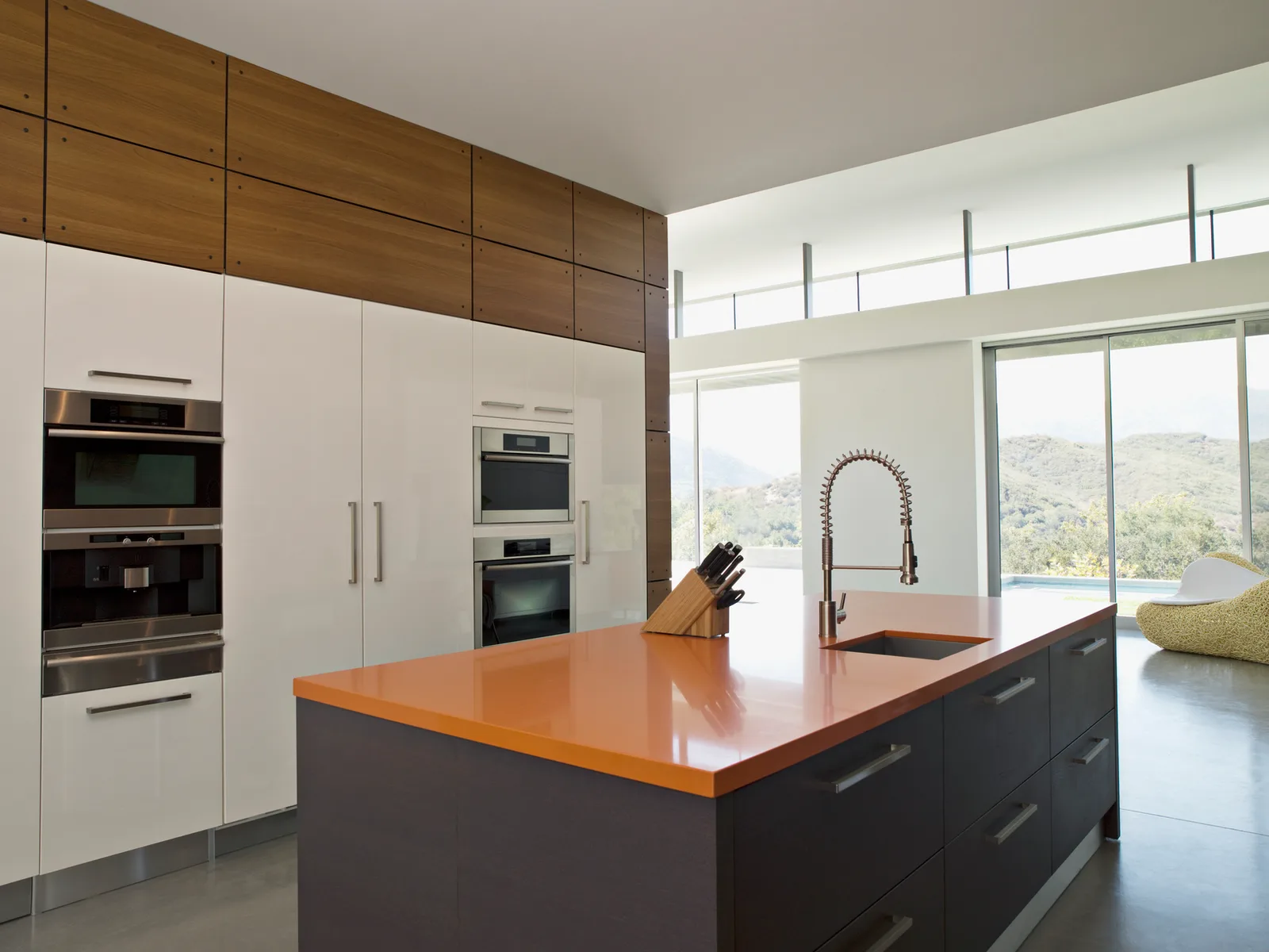 Contemporary kitchen with an orange counter and clerestory windows above the cabinets