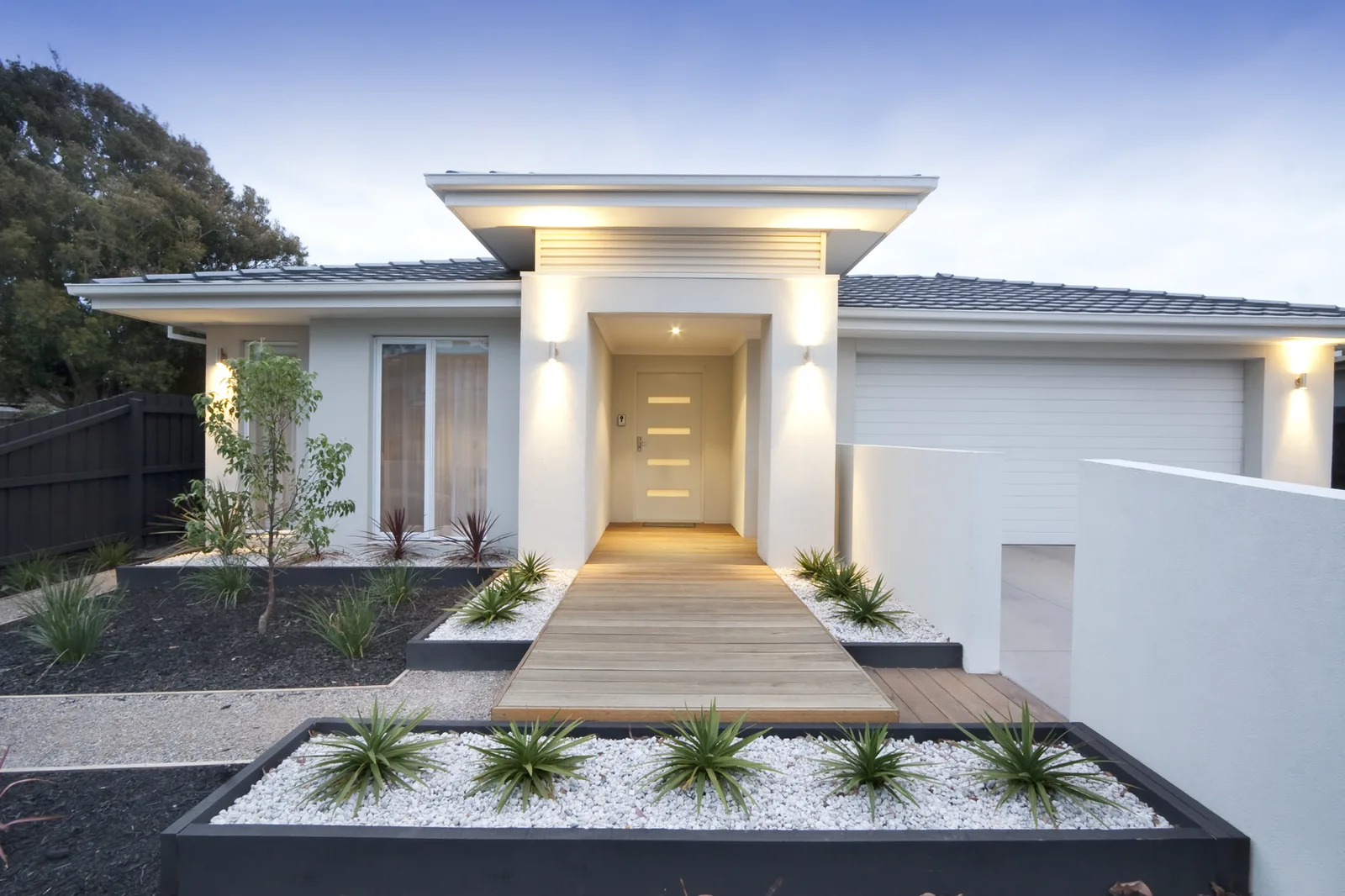 Single-storey house at dusk with a lit entry canopy