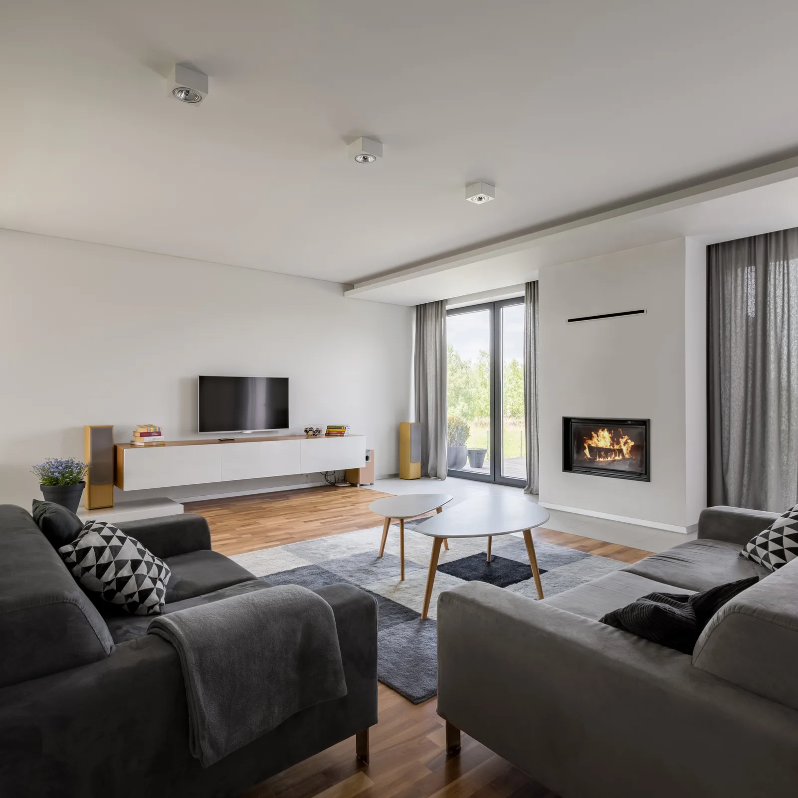 Living room with grey curtains framing a garden door