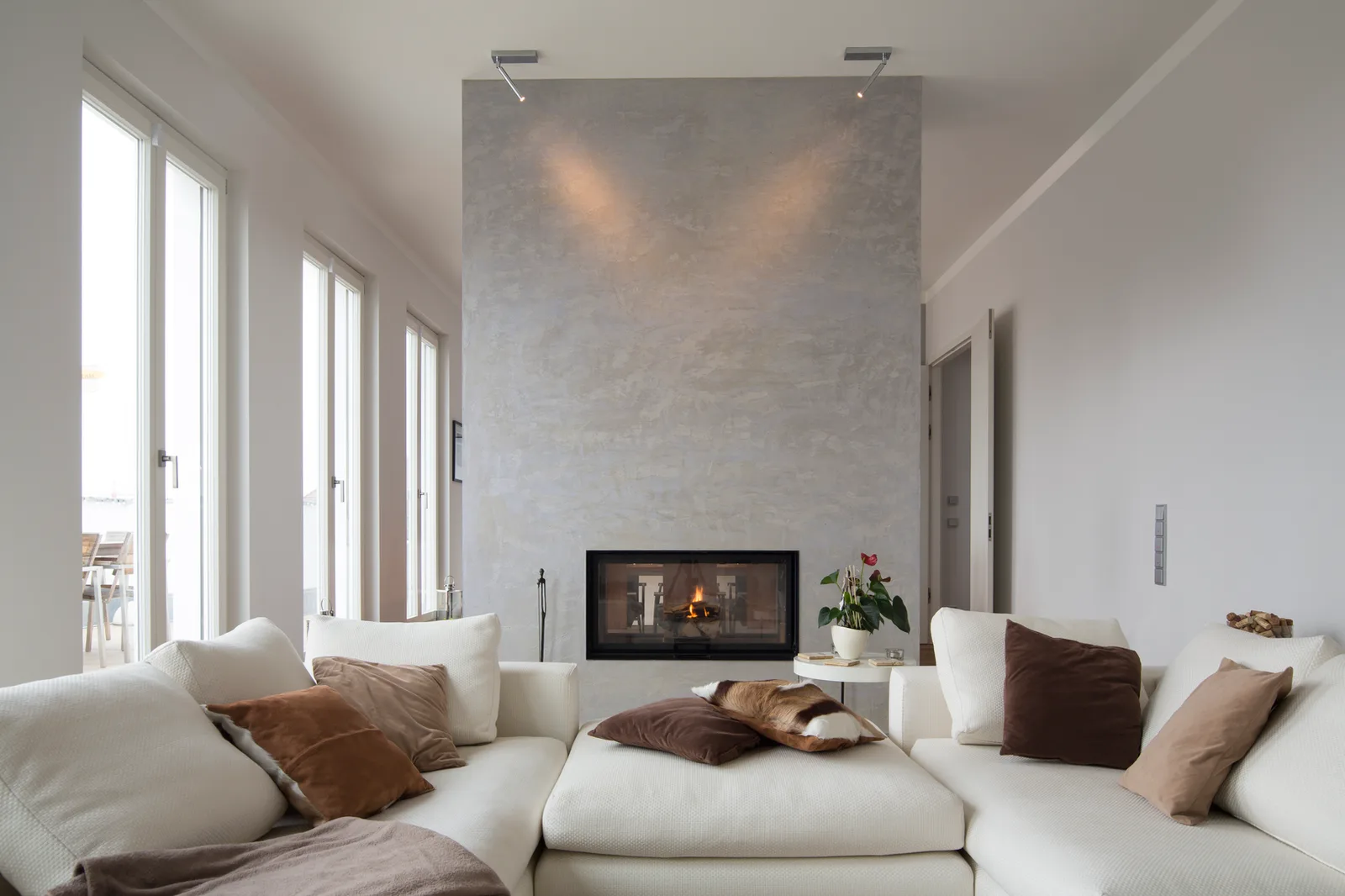 Living room with a plaster fireplace wall and tall narrow windows